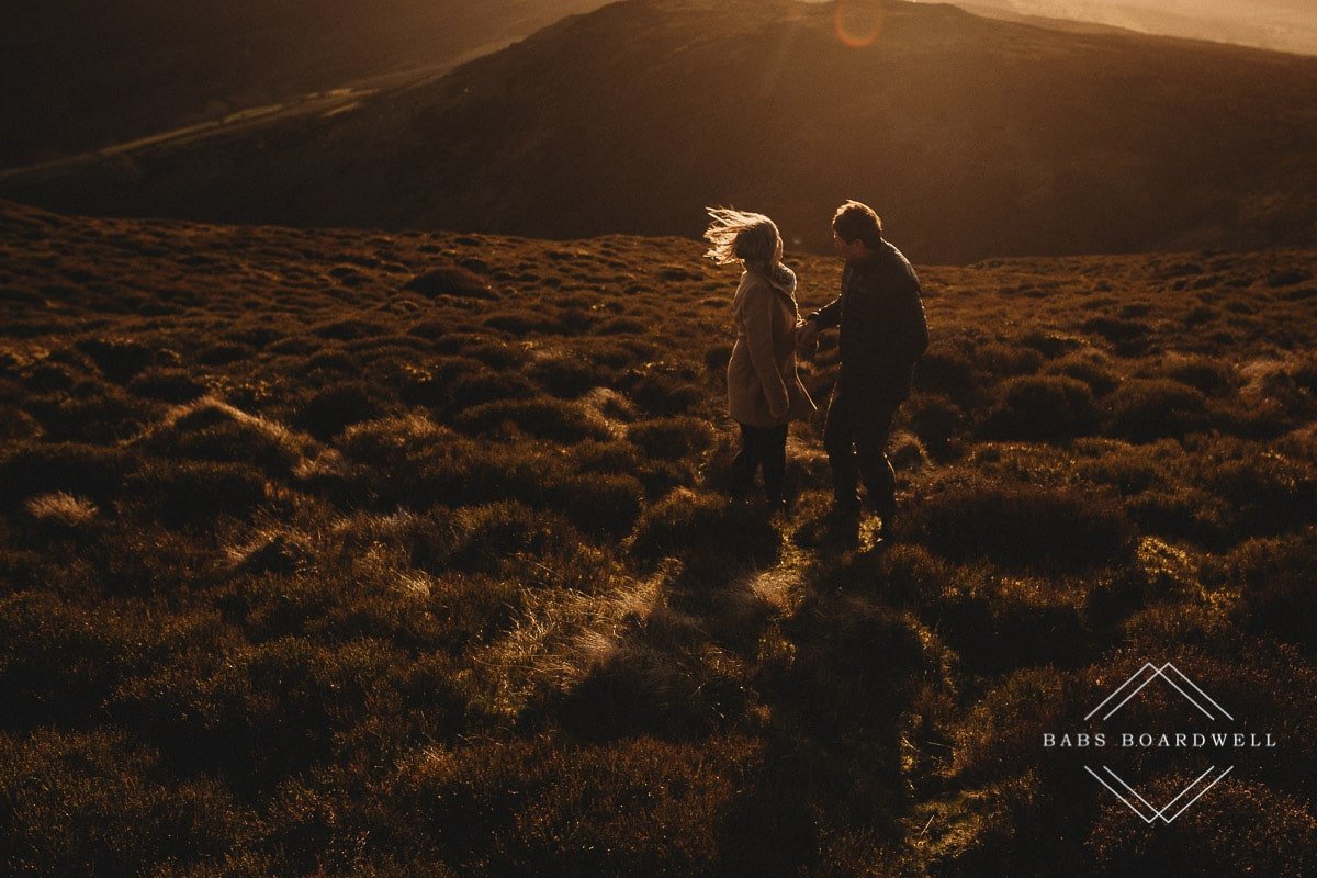 couple at sunset with the woman's hair blowing in the wind