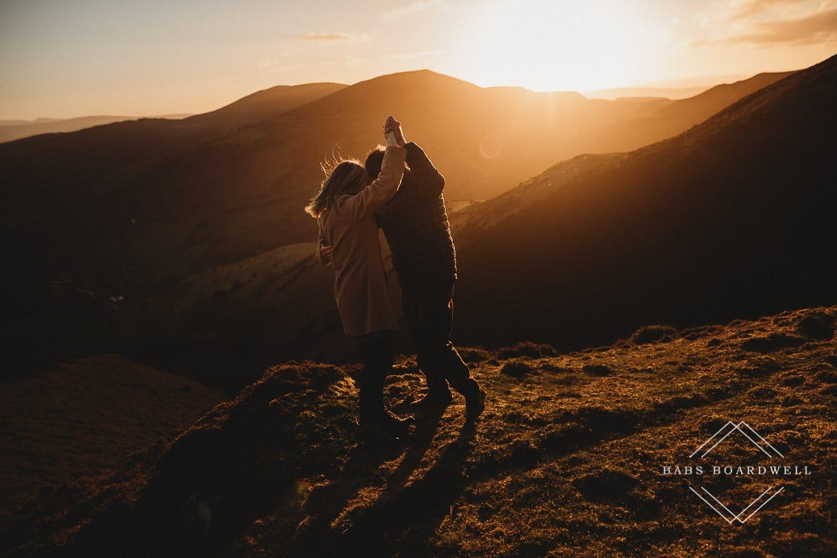 couple pretending to dance at sunset in the Welsh hills