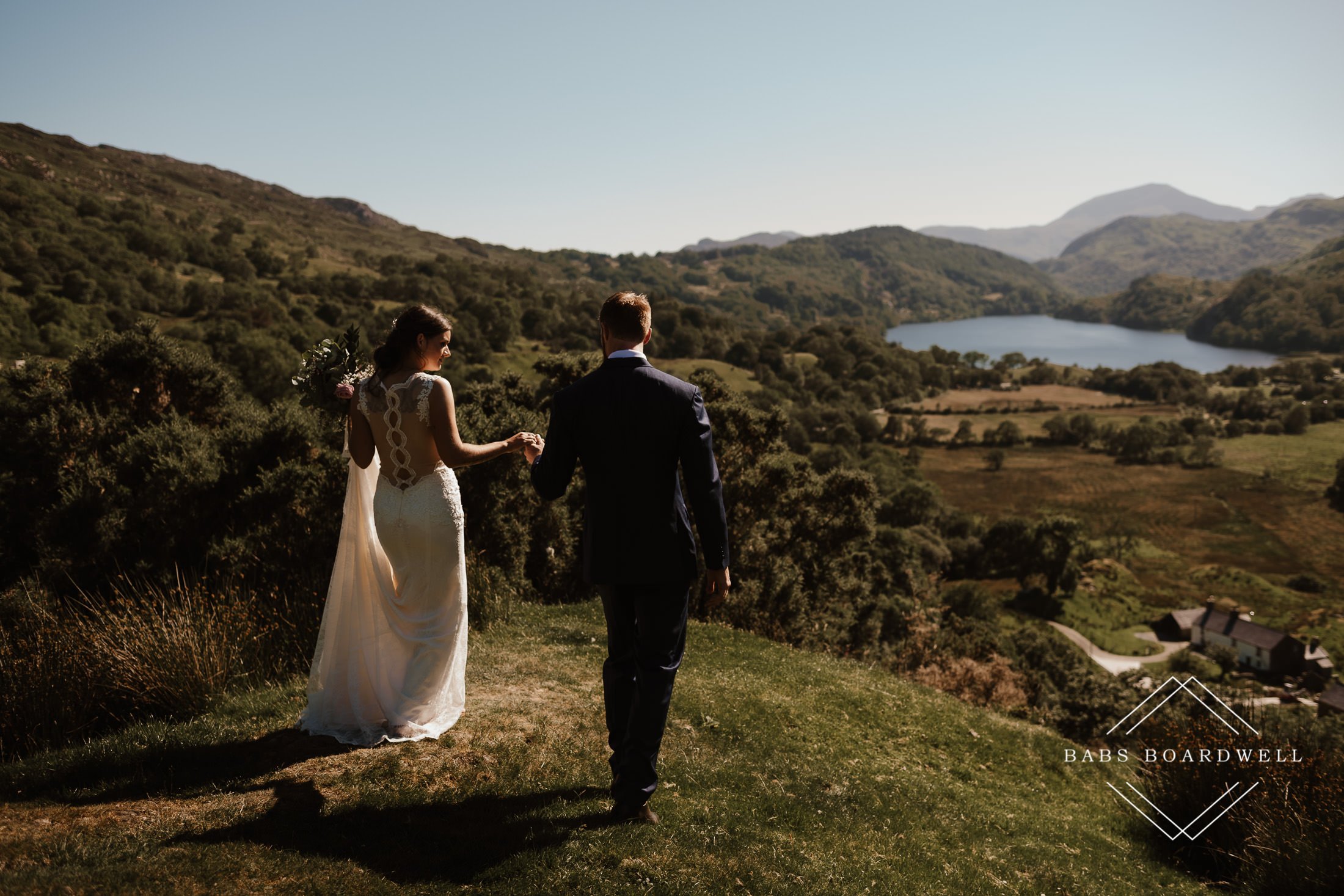 bride and groom walking towards Llyn Gwynant by Snowdonia Wedding Photographer