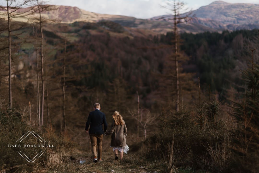 bride and groom walking hand in hand with Cadair Idris in the background by Snowdonia Wedding Photographer