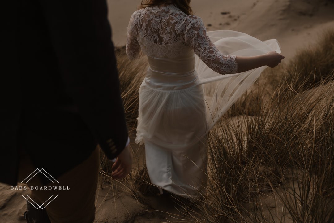 close up of bride's dress details on Barmouth Beach by Snowdonia Wedding Photographer