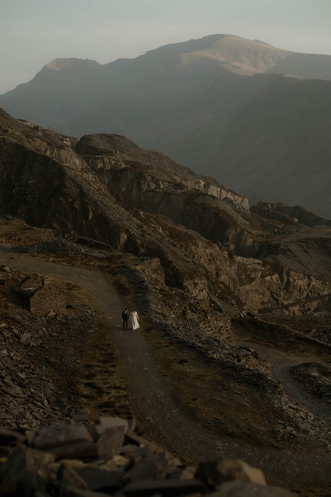 Couple sharing a calm, intimate moment during a post-wedding shoot in Eryri, surrounded by raw, natural landscape.