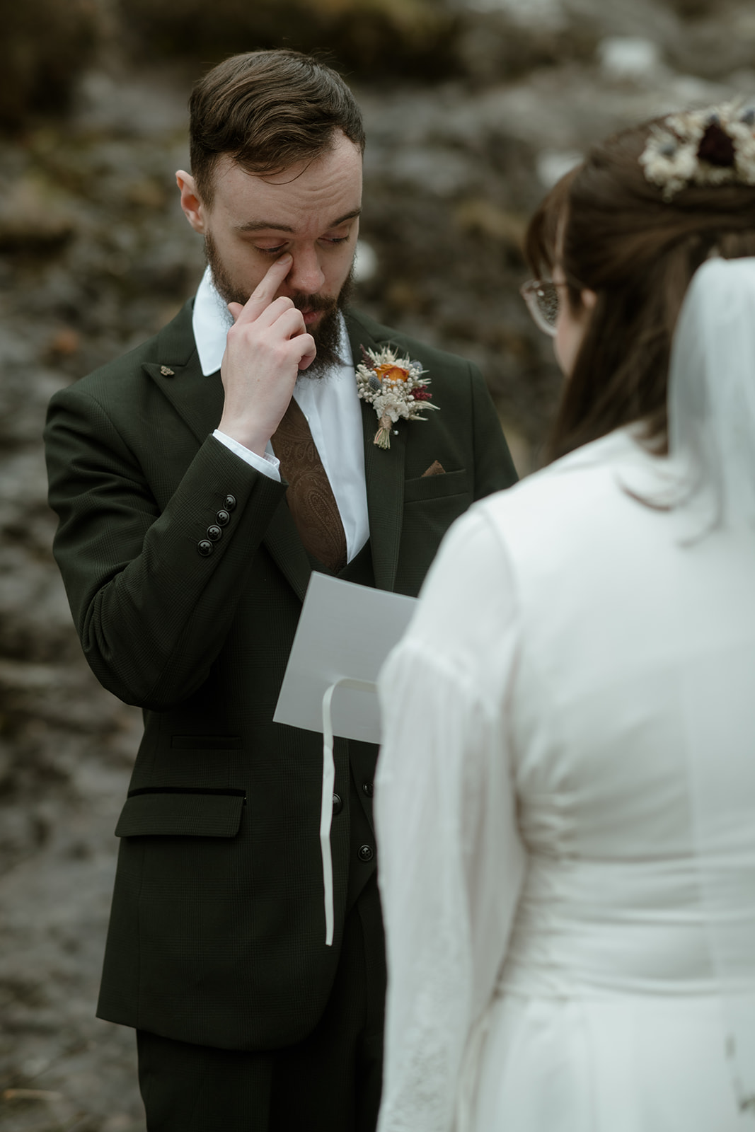 groom reading his vows on his elopement day in Wales and wiping a tear from his eye