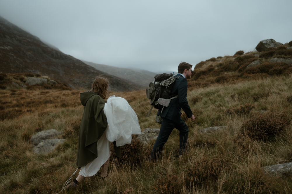 North Wales Elopement Photographer | couple in wedding outfits walking up a mountain in Eryri on their Elopement Day